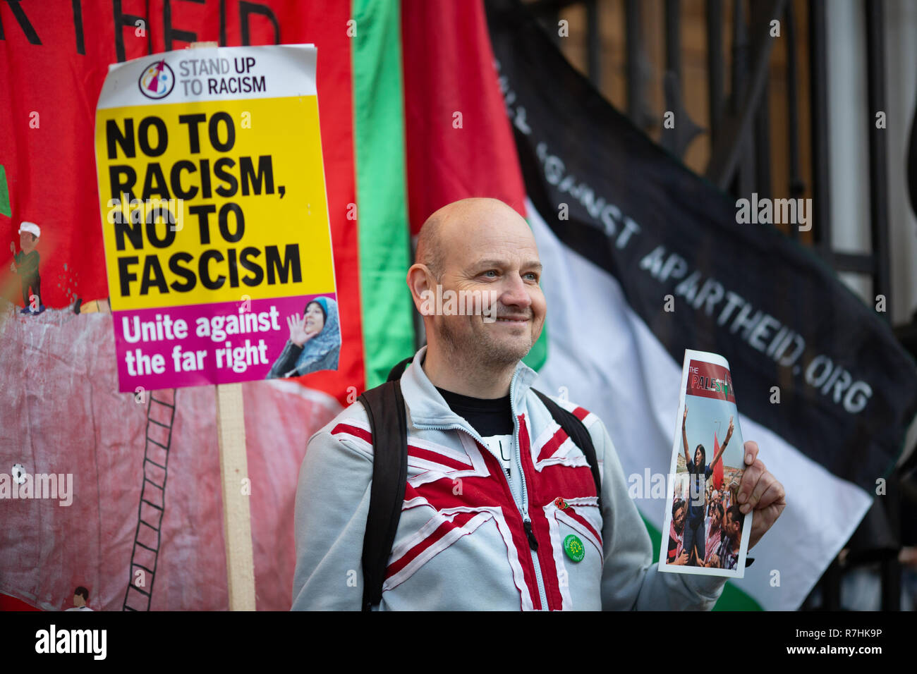A representative of the organisation 'Football Against Apartheid' holds an Anti-Facism sign and poses next to the Palestinian flag.  3,000 Pro-Brexit demonstrators and 15,000 Anti-Facist counter demonstrators took to the streets of London to voice their stance on the deal ahead of the key Brexit vote in parliament this Tuesday. Stock Photo