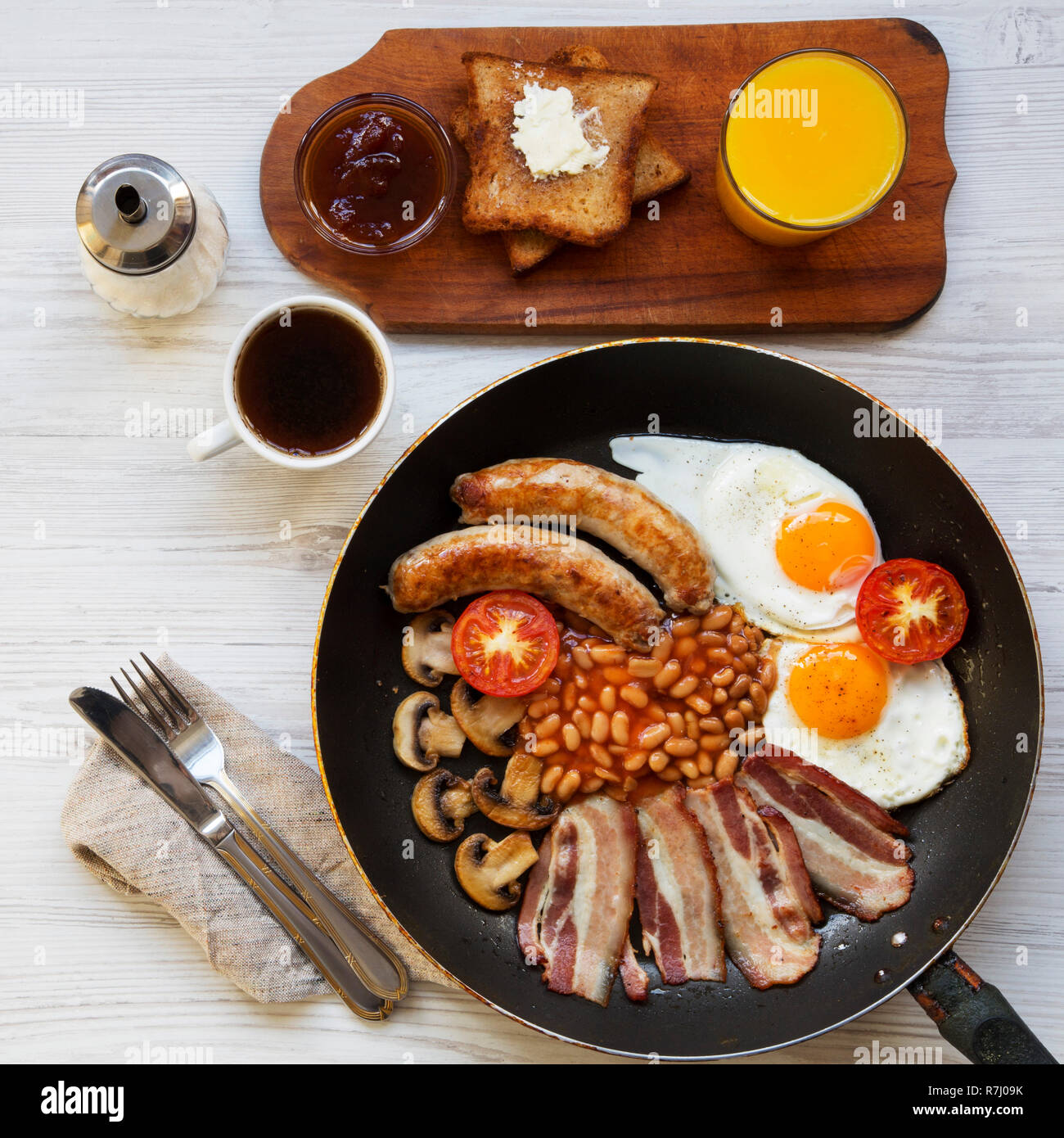Cook Breakfeast Full English breakfast in a pan with fried eggs, bacon, sausages, beans ...
