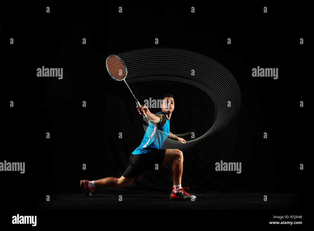 Young man playing badminton over black background. Fit male athlete isolated dark with led light trail . badminton player in action, motion, movement. attack and defense concept Stock Photo - Alamy