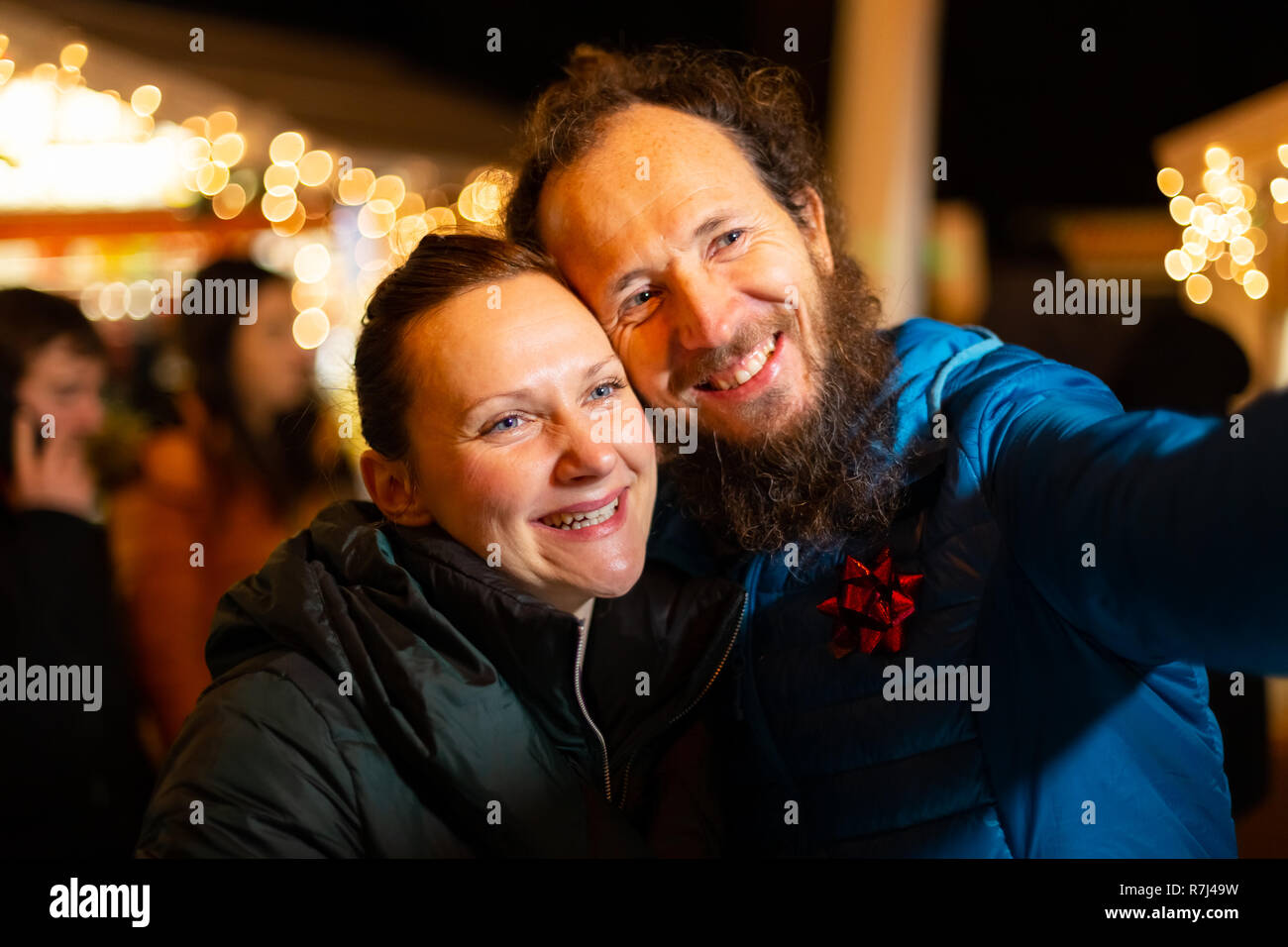 Portrait of couple taking selfie, traditional Christmas market, Zagreb, Croatia. Stock Photo