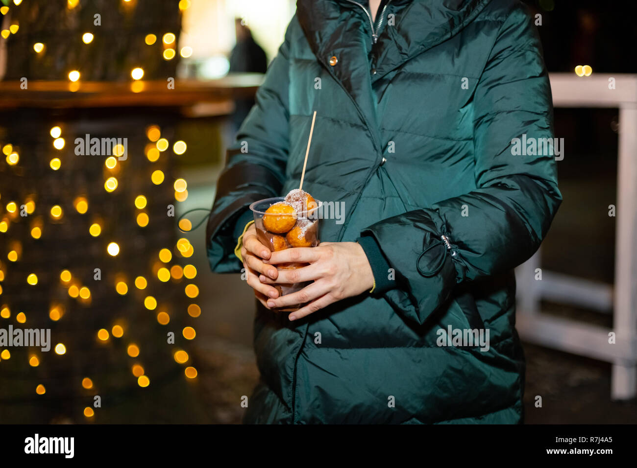 Woman holding traditional fritula at Christmas market. Zagreb, Croatia Stock Photo
