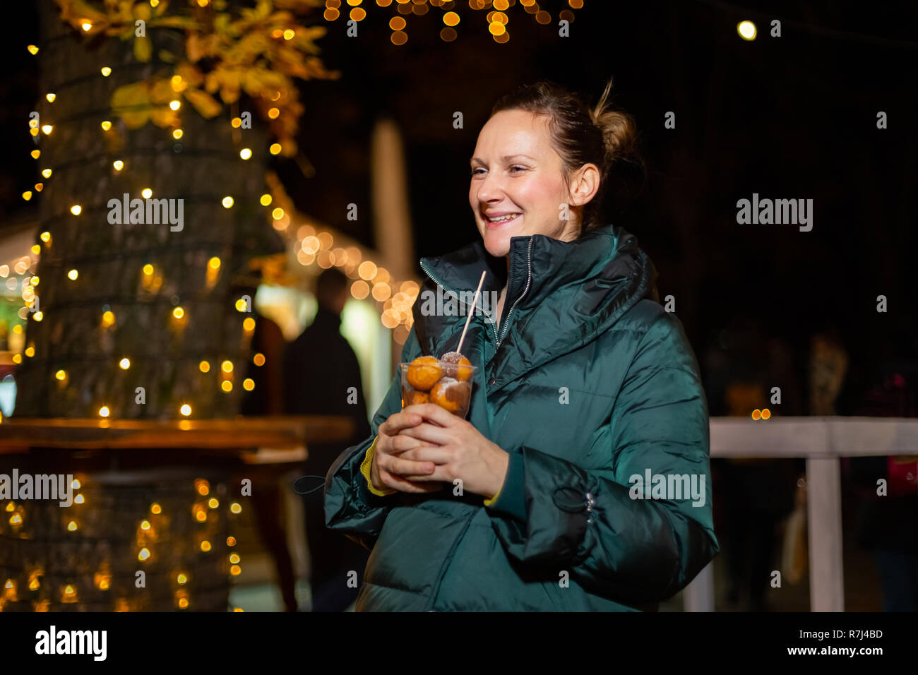 Happy woman holding traditional food at Christmas market. Zagreb, Croatia Stock Photo