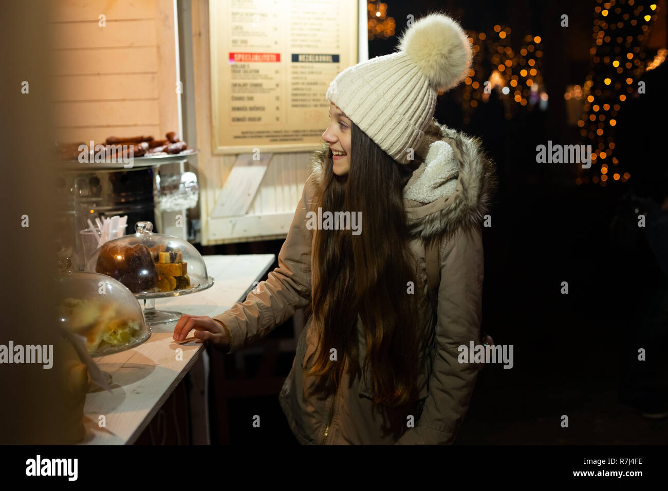 Beautiful teenager looking at traditional Christmas market food stand, Zagreb, Croacia. Stock Photo