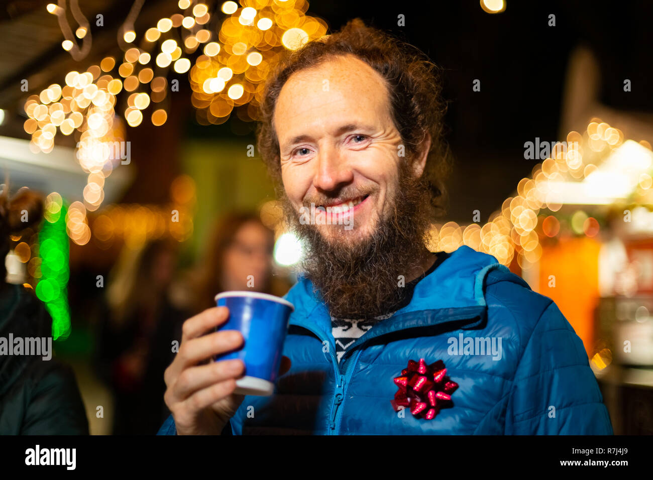 Happy man holding traditional drink at Christmas market. Zagreb, Croatia. Stock Photo