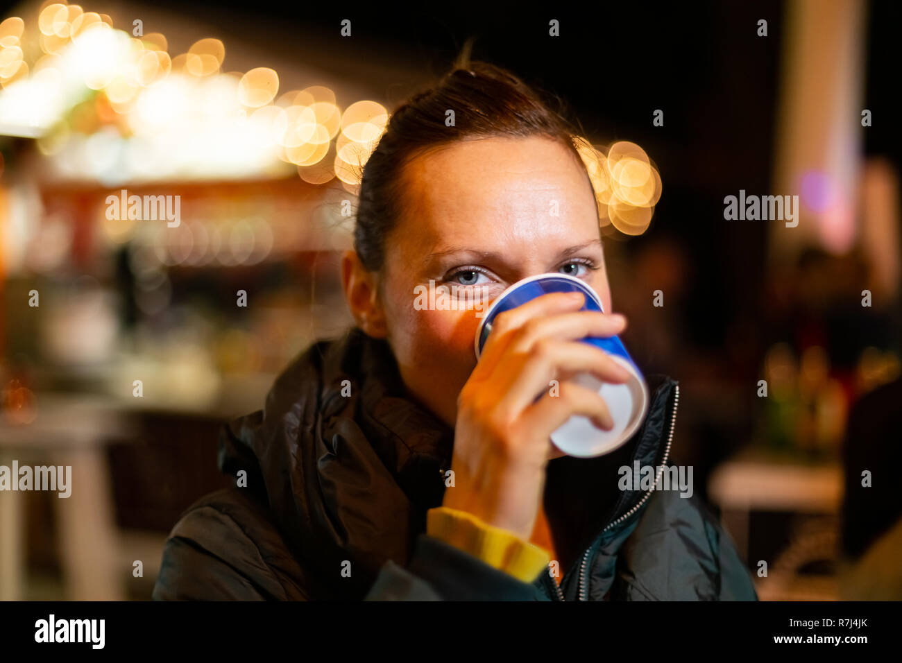 Woman drinking traditional beverage at Christmas market. Zagreb, Croatia. Stock Photo