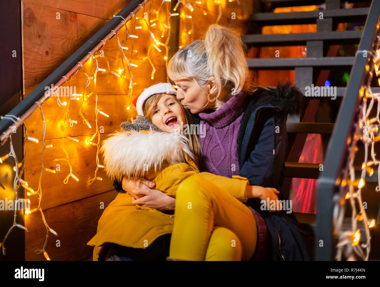 Mother kissing cheek of daughter at Christmas market, Zagreb, Croatia. Stock Photo