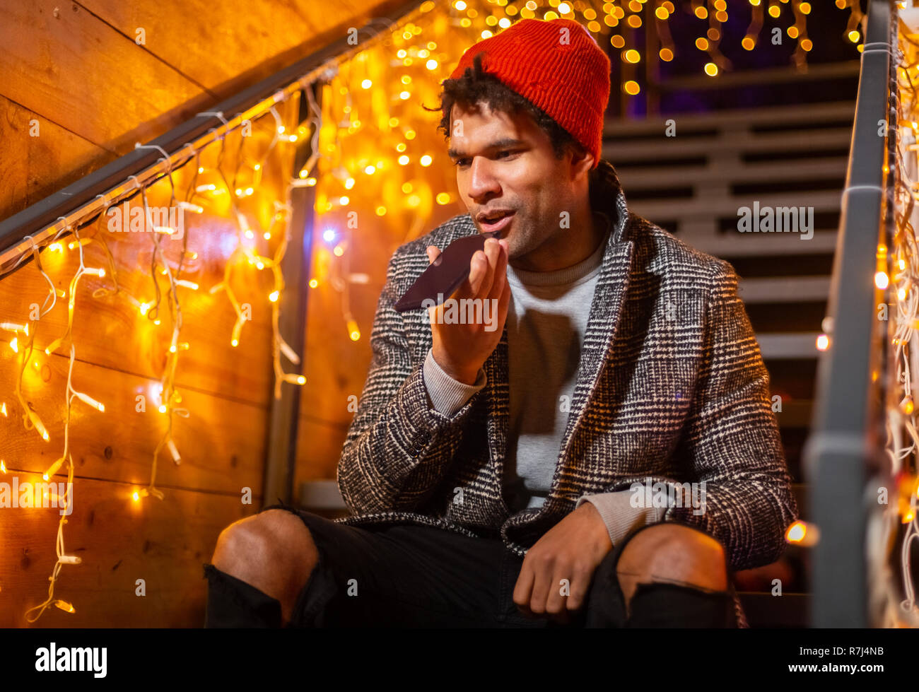 African american man sending audio on cell phone at Christmas market, Zagreb, Croatia. Stock Photo