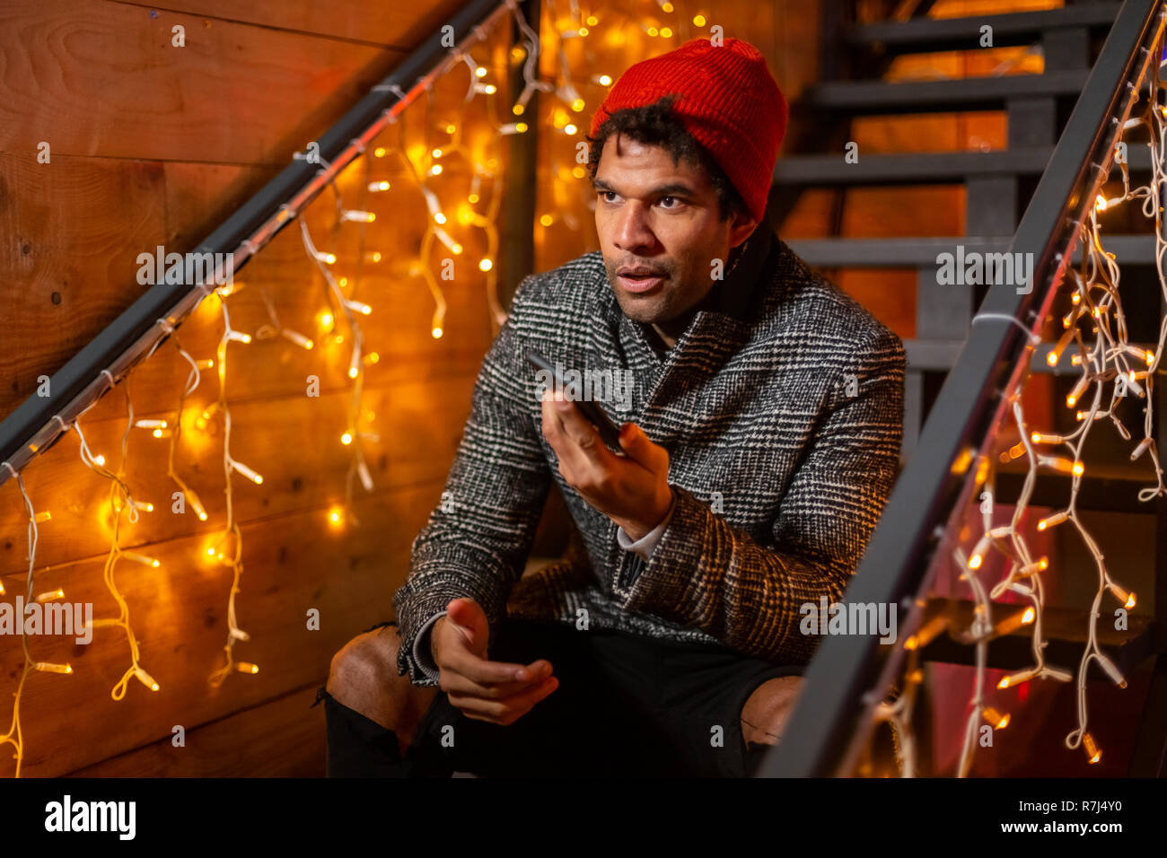 Portrait of african american man sitting on stairs at Christmas market, Zagreb, Croatia. Stock Photo