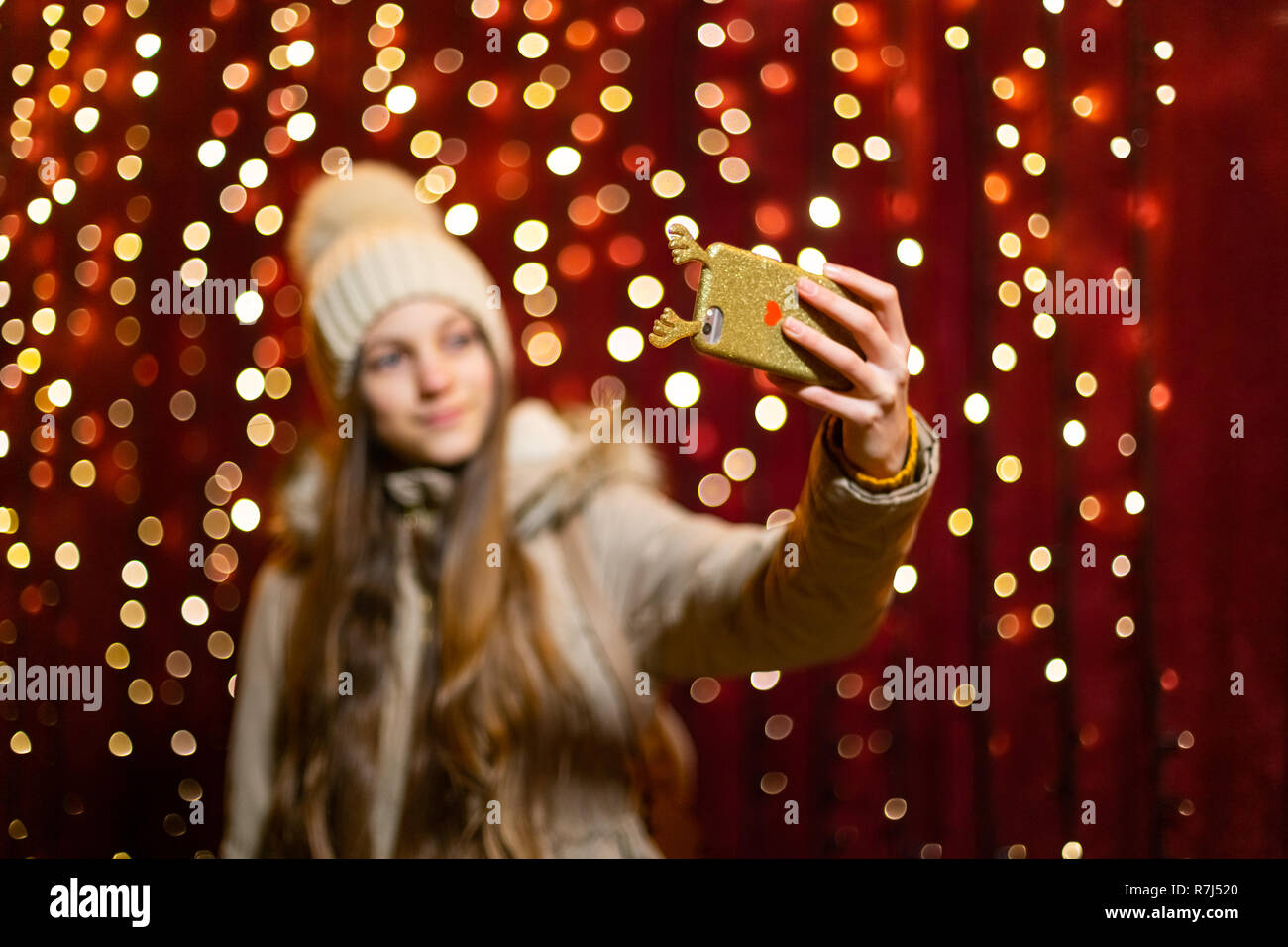 Beautiful teenager taking a selfie at Christmas market. Stock Photo
