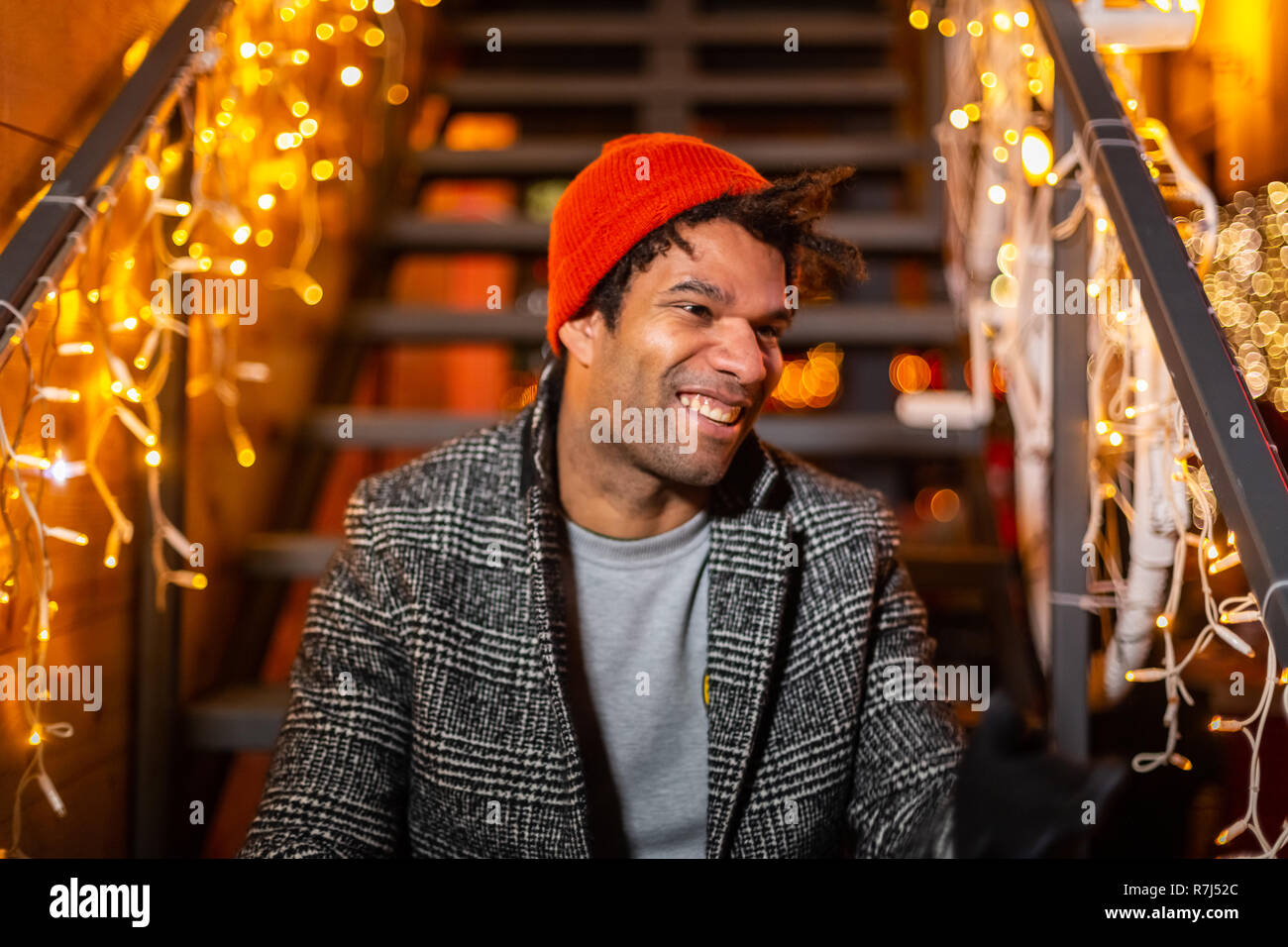 Portrait of african american man sitting on stairs at Christmas market, Zagreb, Croatia. Stock Photo