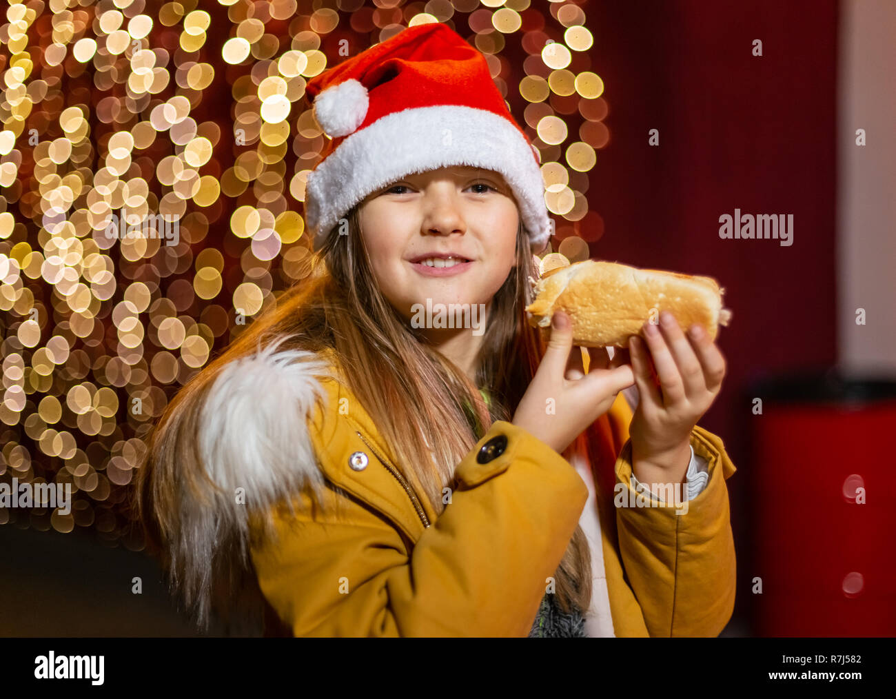 Cute teenager eating hot dog at Christmas market, Zagreb, Croatia. Stock Photo
