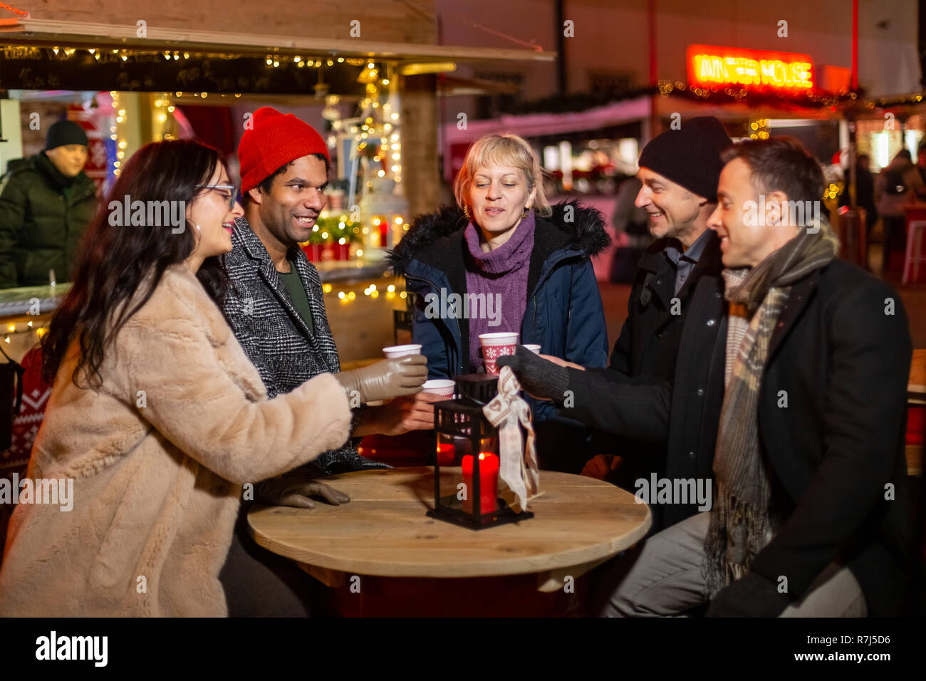 Group of friends cheering with traditional drink at Christmas market, Zagreb, Croatia. Stock Photo