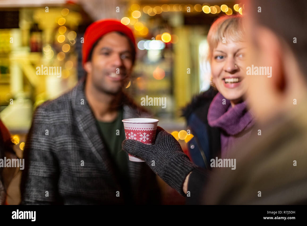 Close up image of man cheering with friends at Christmas market, Zagreb, Croatia. Stock Photo