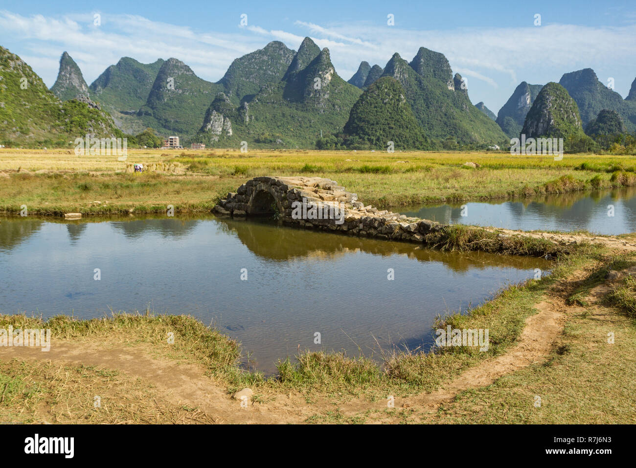 Stone bridge in picturesque valley surrounded by karst limestone hills