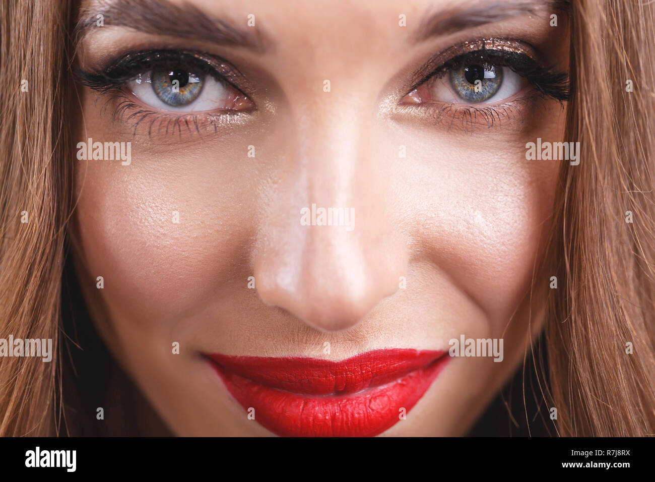Cropped view of attractive romantic long haired woman with red lips wearing black dress standing on the gray background Stock Photo