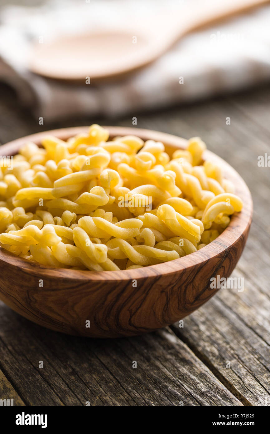 Uncooked gemelli pasta in wooden bowl. Stock Photo