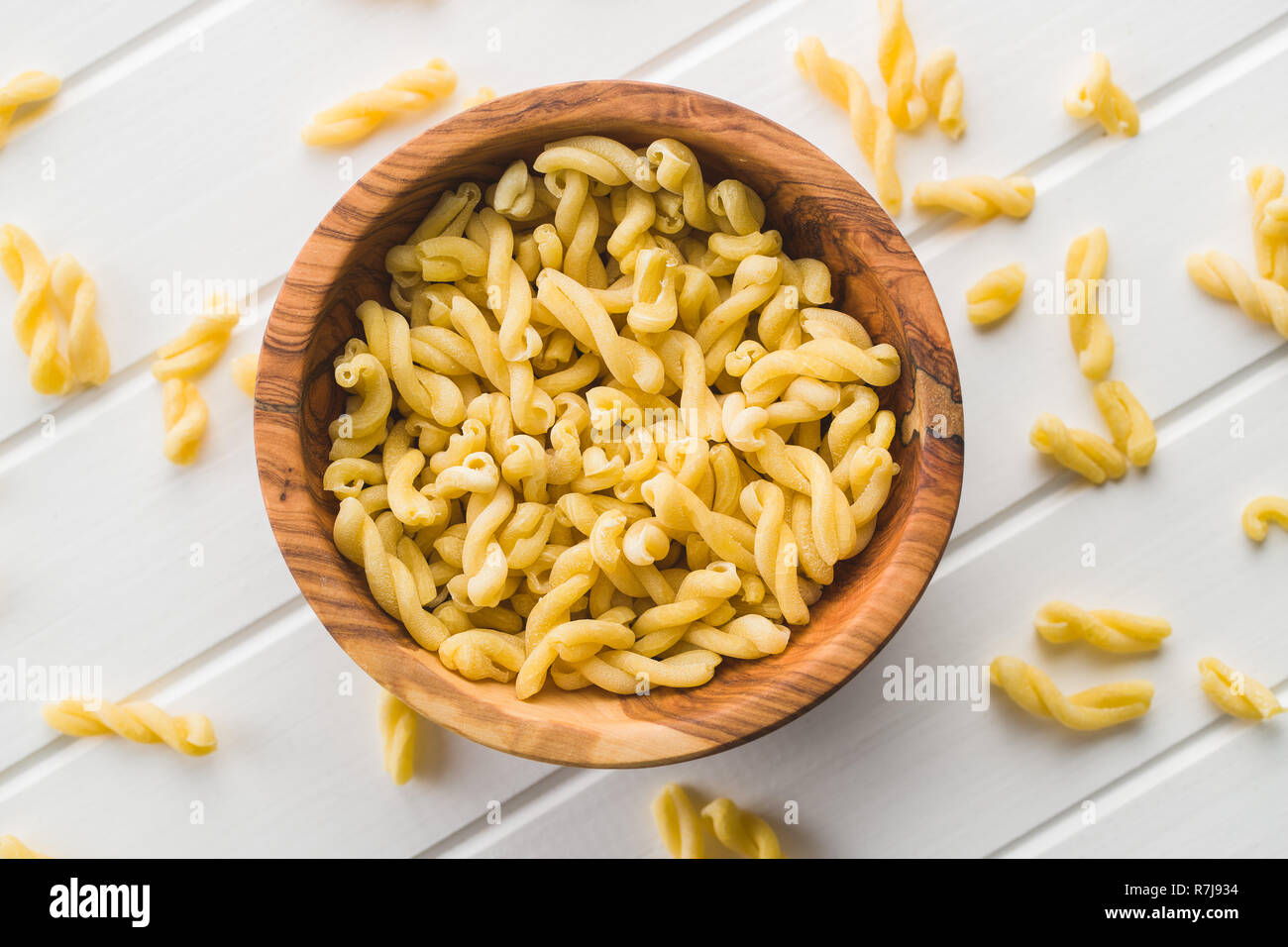 Uncooked gemelli pasta in wooden bowl. Stock Photo