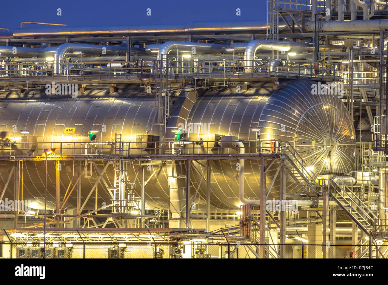 Giant container in Chemical factory at night. Petrochemical background. Stock Photo