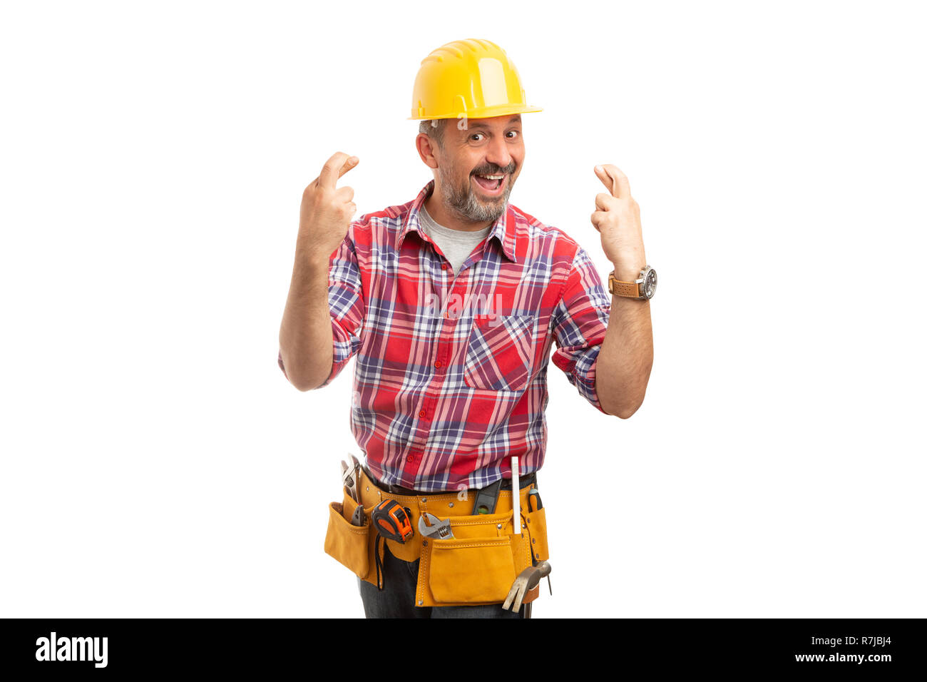 Cheerful builder holding up both hands with fingers crossed as good luck concept isolated on white background Stock Photo
