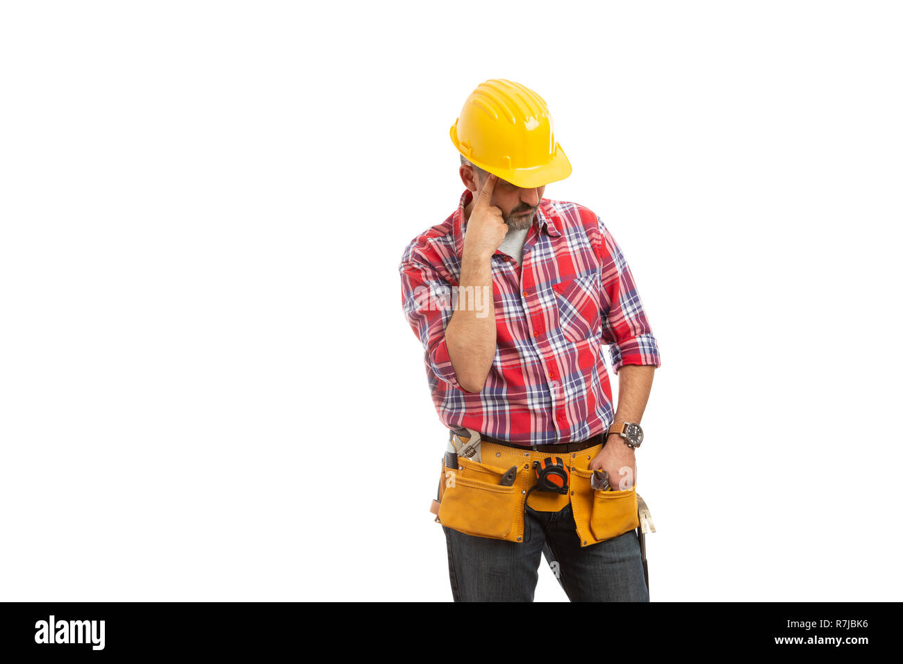 Thoughtful constructor planning while looking down with index finger touching forehead isolated on white background Stock Photo
