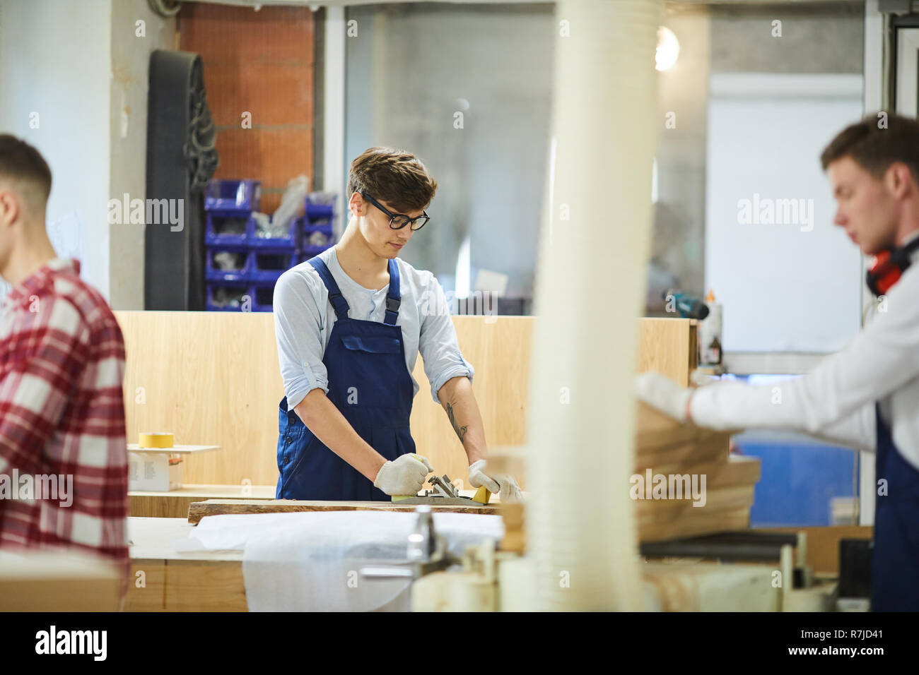 Young carpenter using planer in workshop Stock Photo
