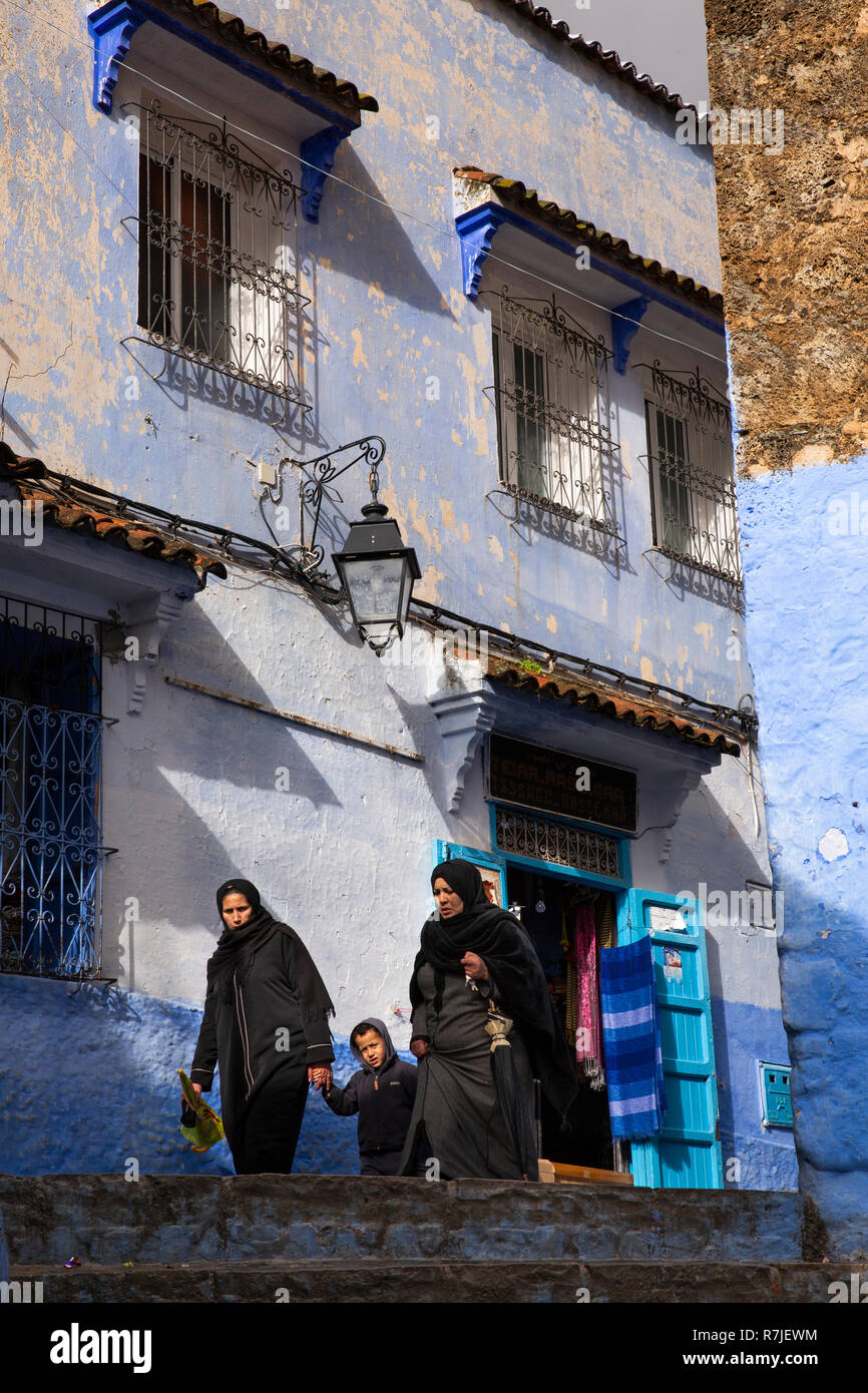 Morocco, Chefchaouen, Medina, Moslem women walking past blue painted house Stock Photo