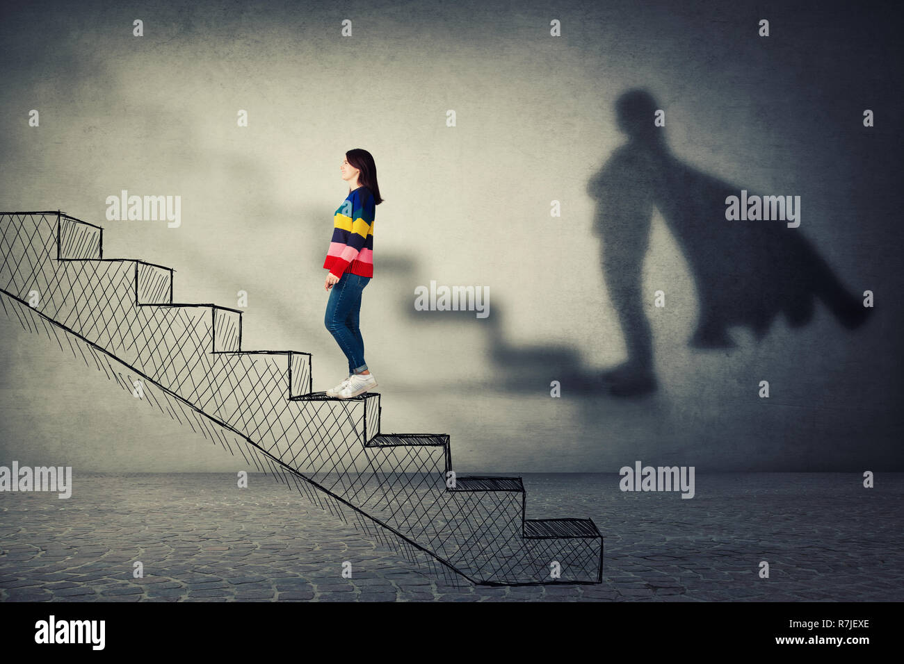 Happy young woman climbing a imaginative stairway with aspiration of becoming superhero. Dream of success, inner power and confidence symbol. Stock Photo
