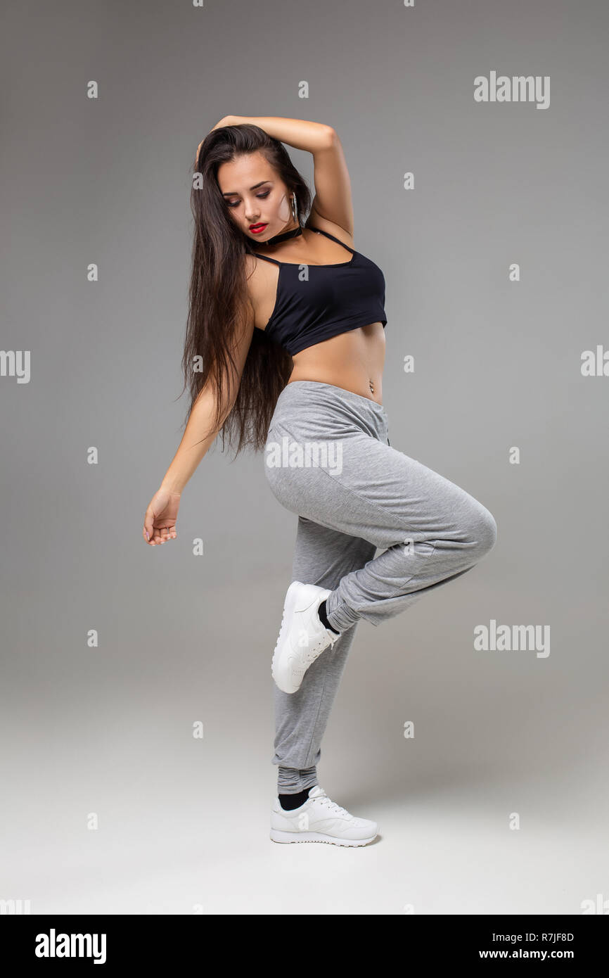 Modern style dancer posing on studio background. Hip hop, jazz funk