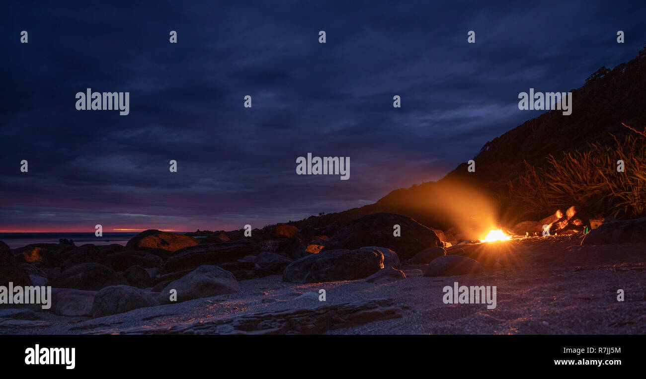 Campfire on the beach, with sunset. Long exposure. Stock Photo