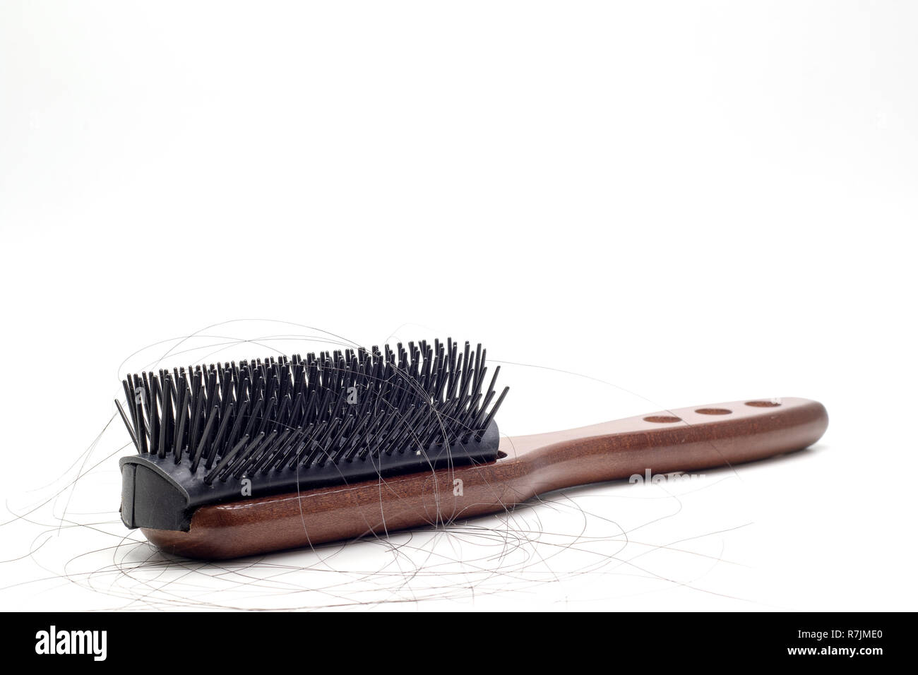 Close up view Brown hair comb and hair loss on white background. Stock Photo