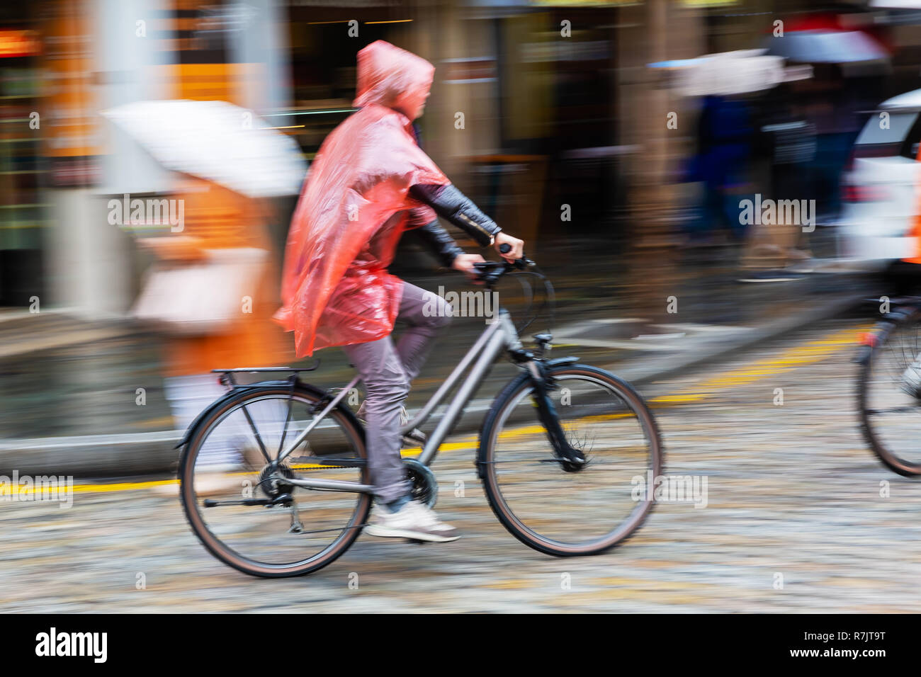 picture with camera made motion blur effect of a person with rain cape ...