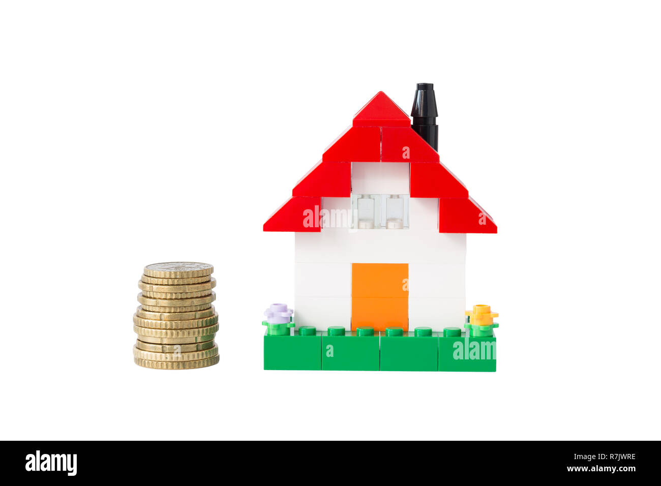 Stack of coins and simple house made of toy building bricks, isolated on white.Concept photo of mortgage,real estate business or house ownership. Stock Photo