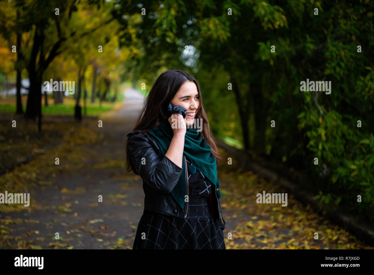 Happy young woman having a conversation using a smartphone on a phone call. Stock Photo