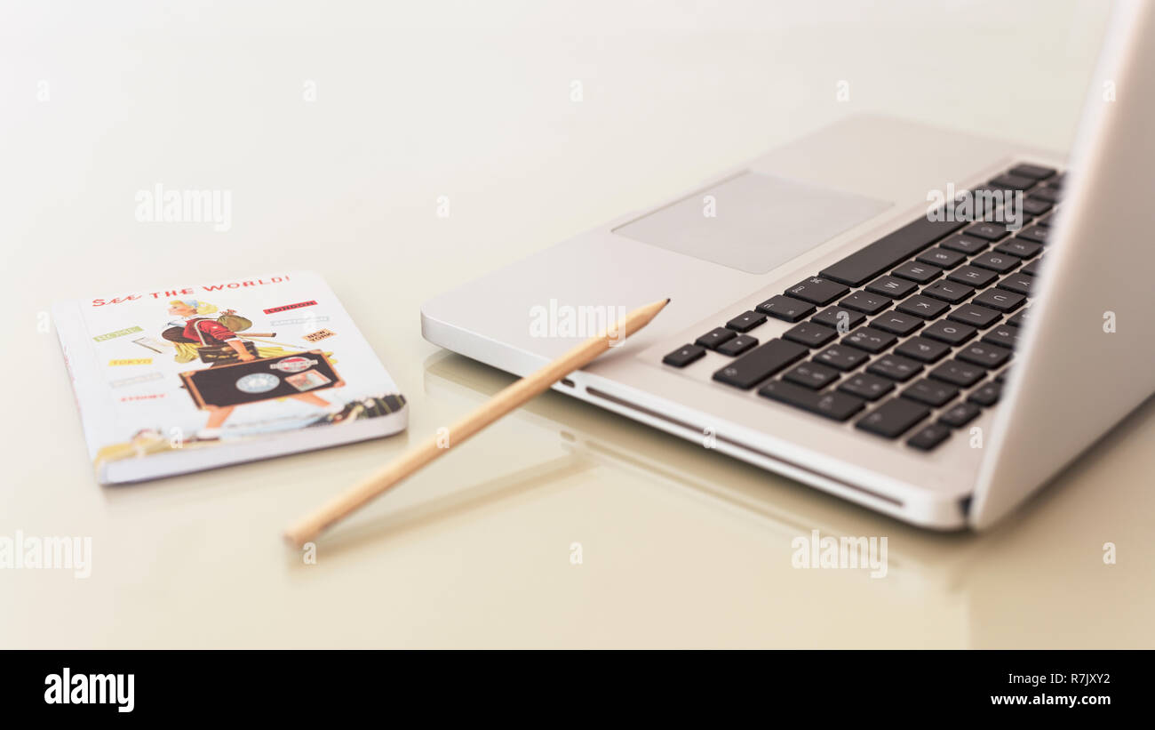 Laptop portable computer notebook on a table workspace office with a pencil and a small diary, book for freelancer, writers, white background. Stock Photo