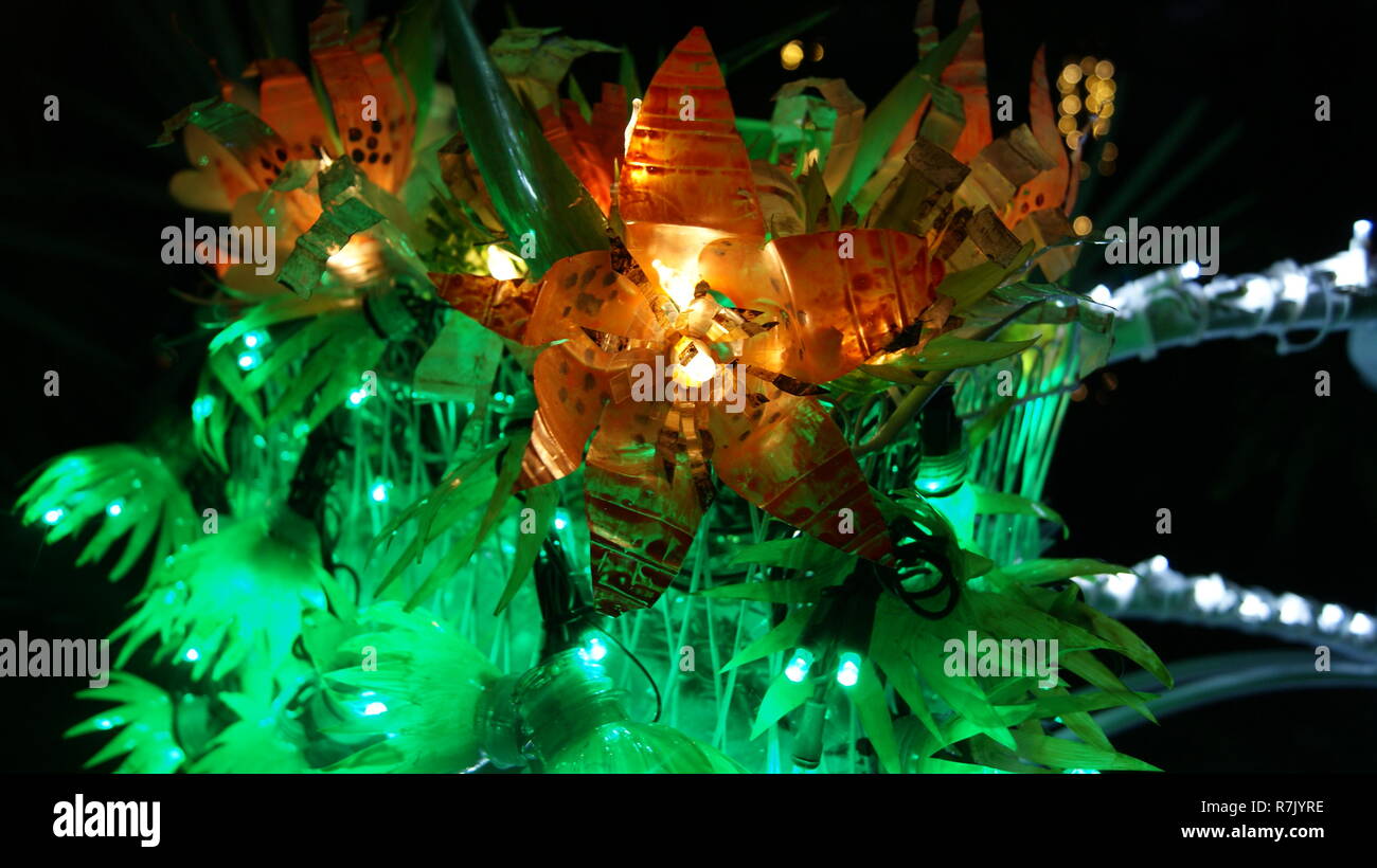 Close up picture of an orange flower made with fairy christmas lights shining at night in a garden Stock Photo
