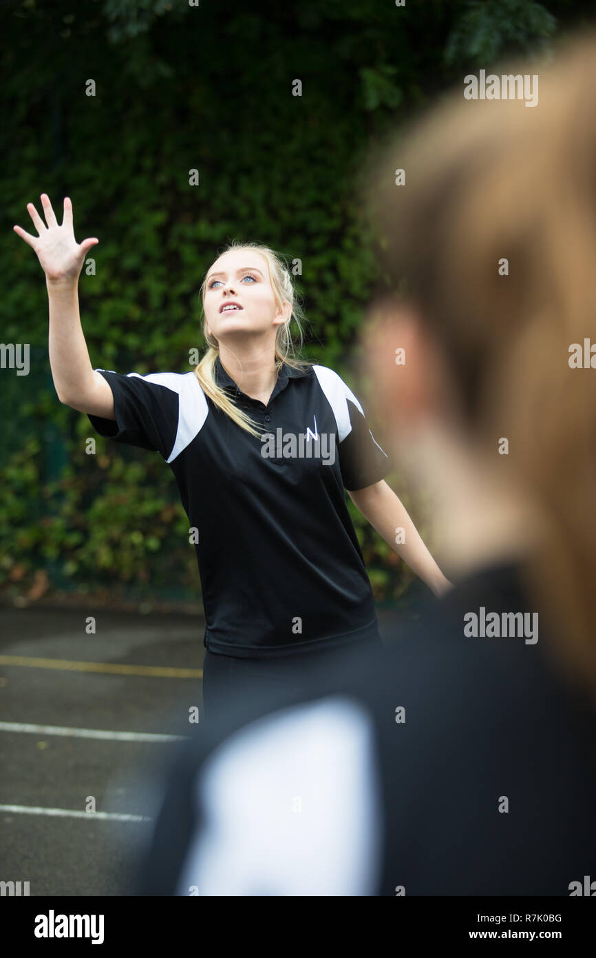 15 year old girls doing PE (physical education) in a UK school playground Stock Photo