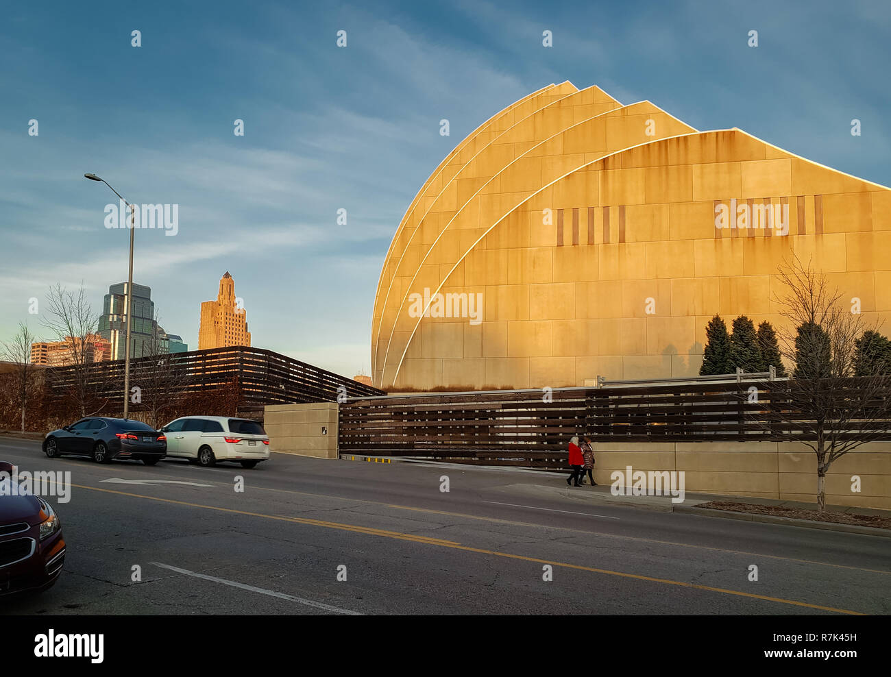 View of Kauffman Center for Performing Arts Center  in Kansas City, Missouri, and street in front of it at sunset; other buildings in background Stock Photo