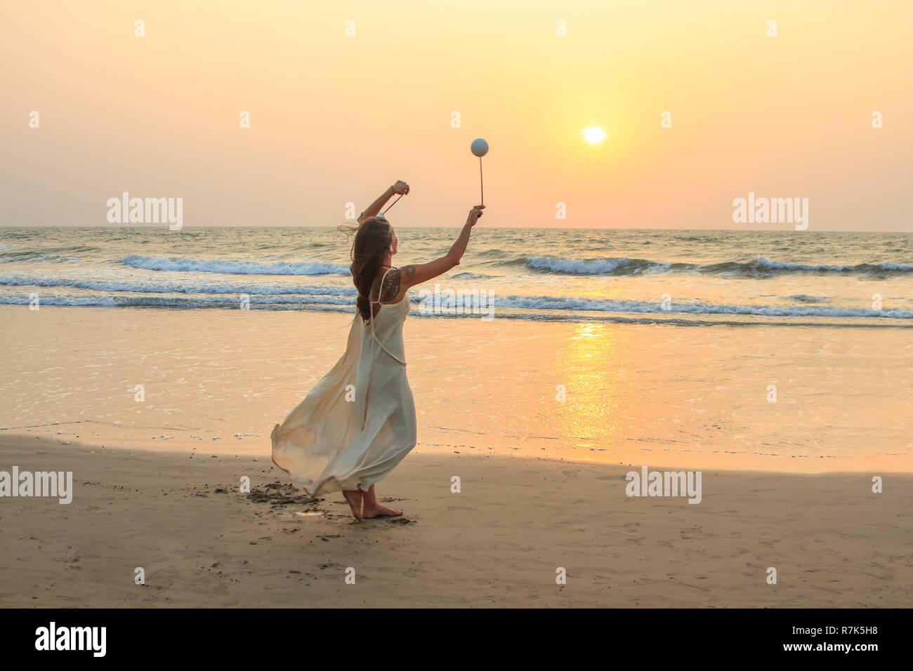 Goa, India - February 15, 2016: Unidentified woman spinning poi on the beach. Stock Photo