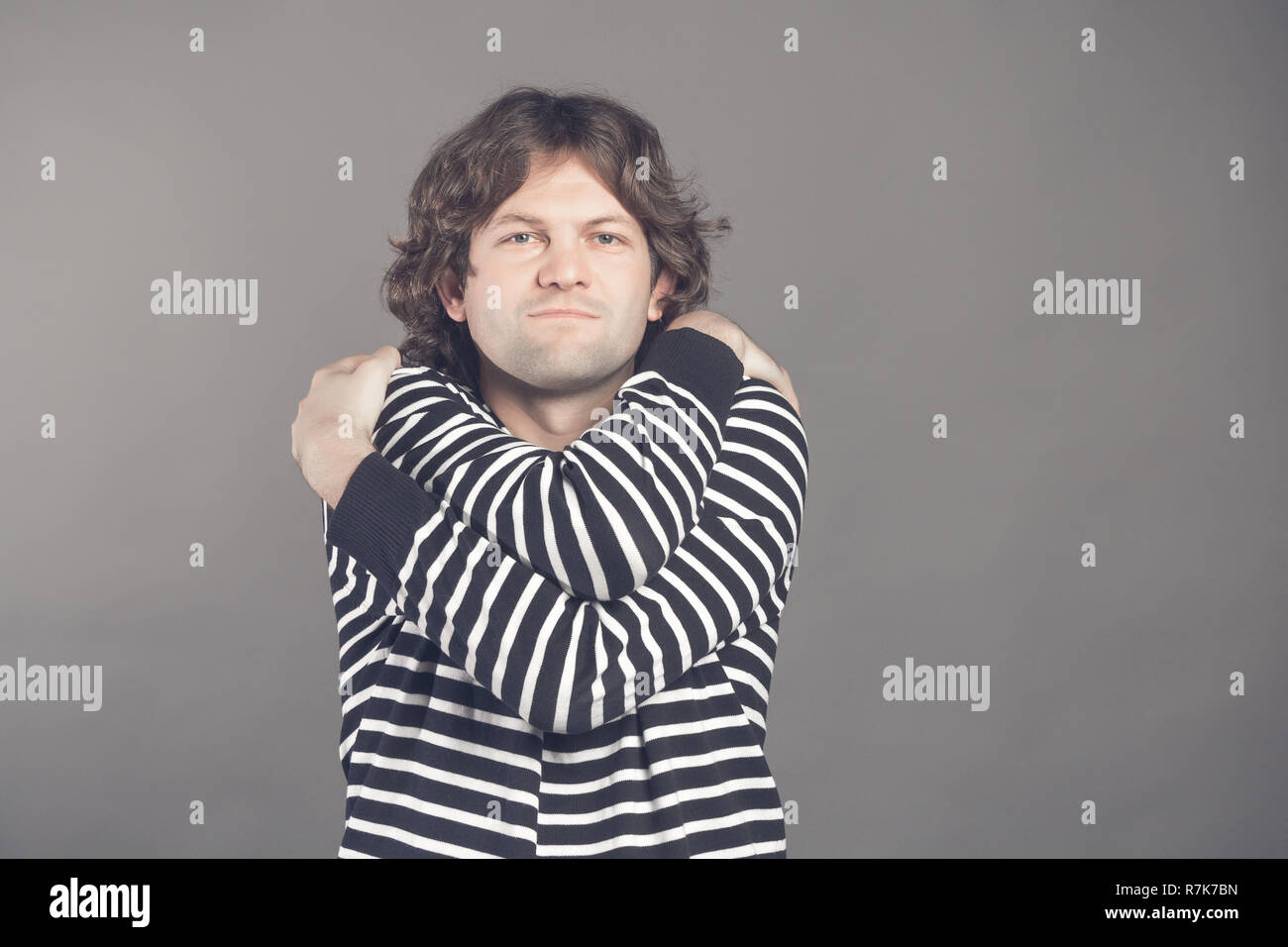 Closeup portrait of confident smiling man holding hugging himself
