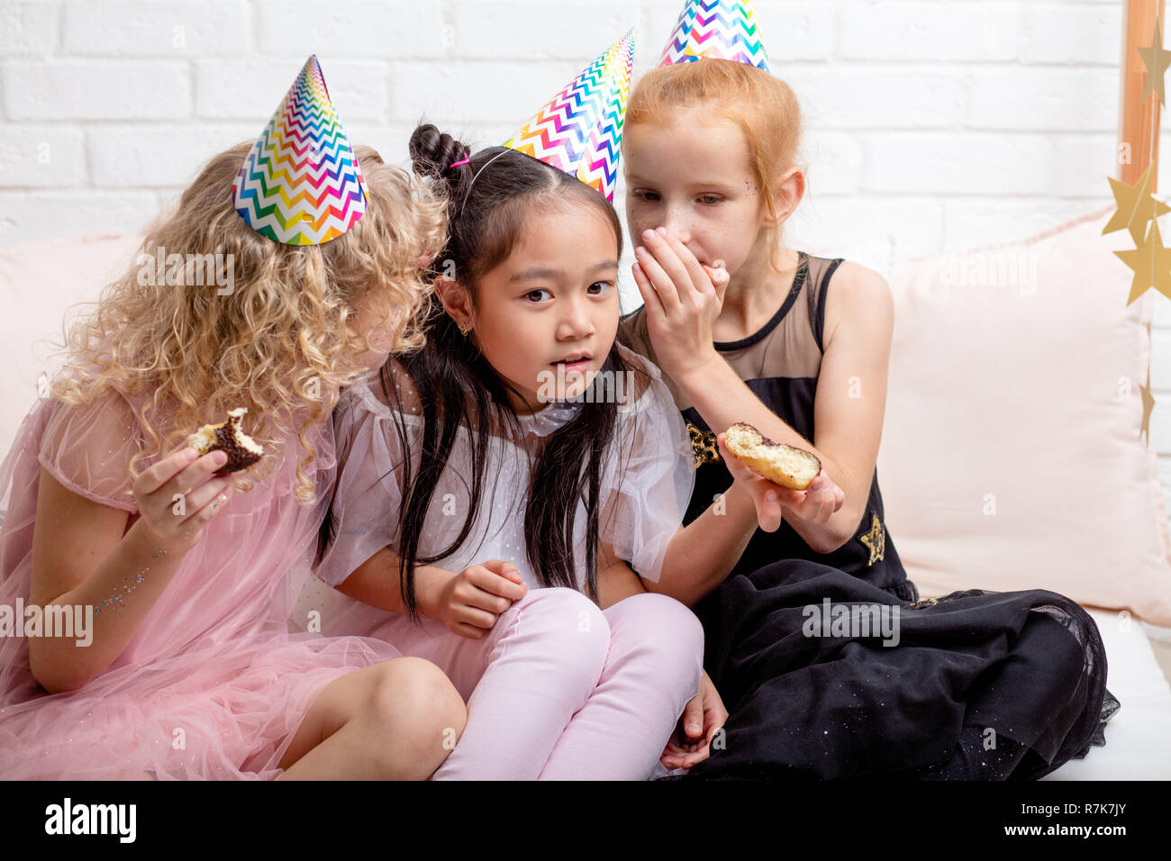 two girl whispering something to their friend Stock Photo - Alamy