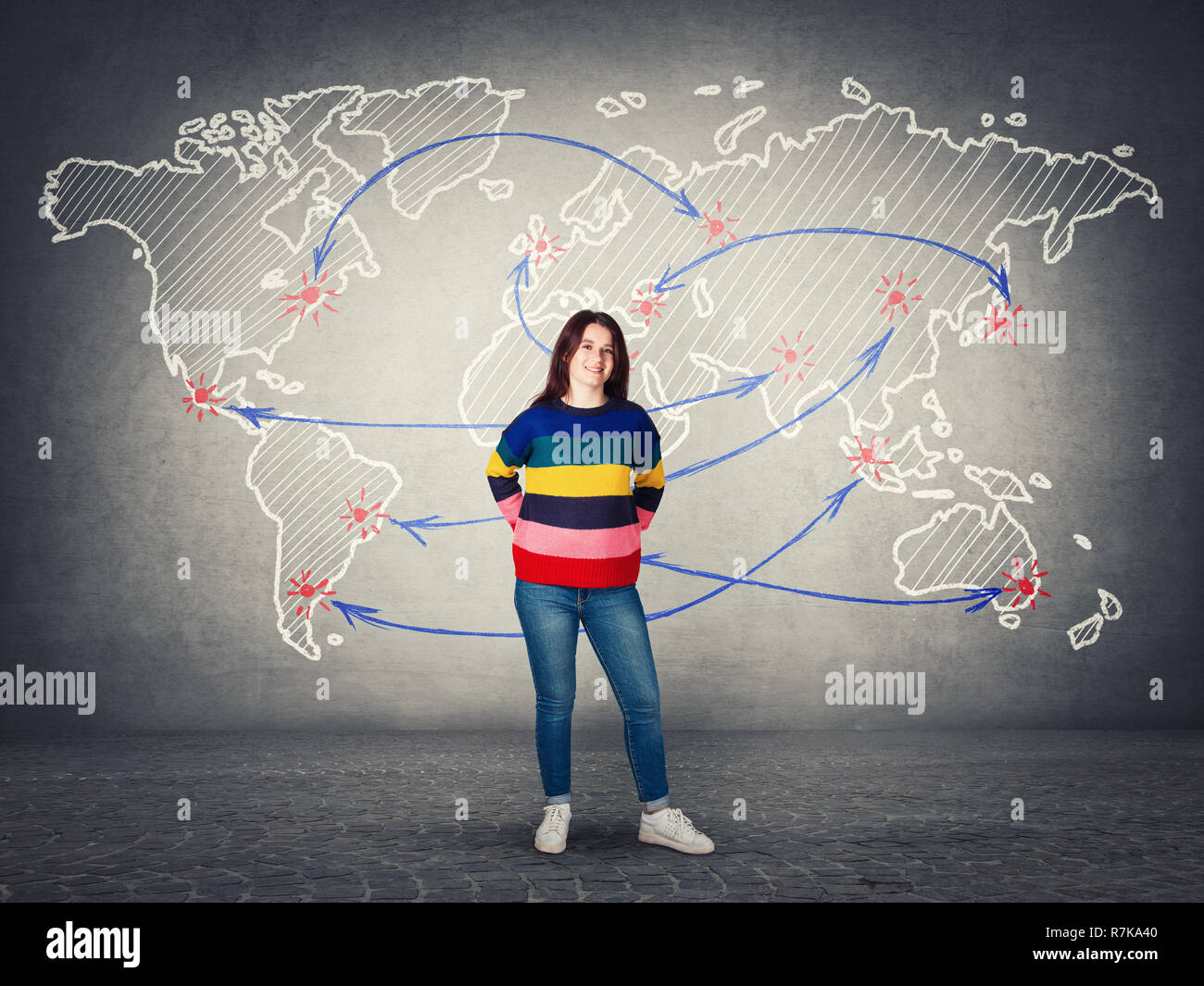 Happy casual young woman ready for holiday trip isolated over grey wall with world map and journey destinations as points and arrows sketches. Beginni Stock Photo