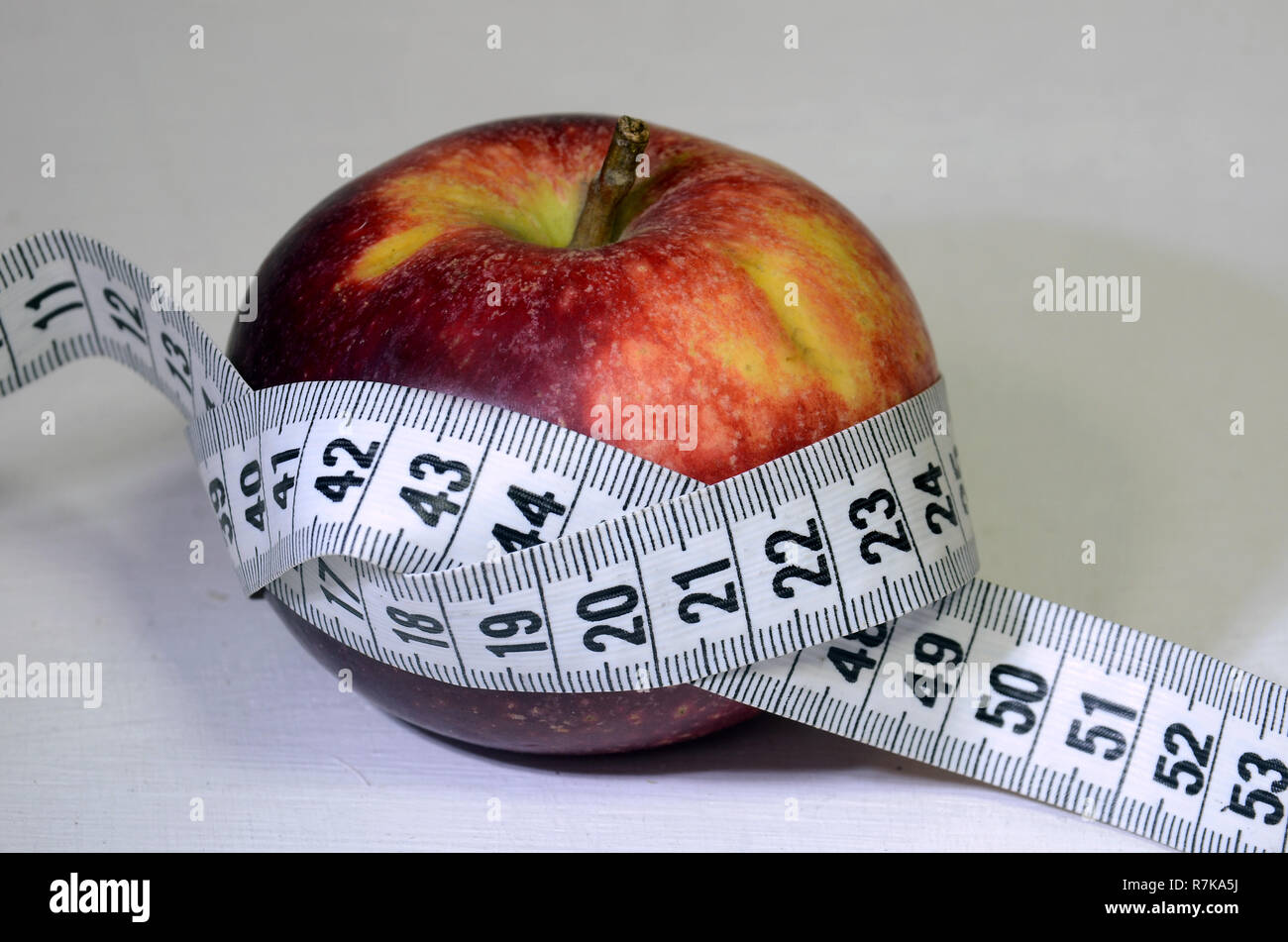 Red apple with measuring band. Stock Photo