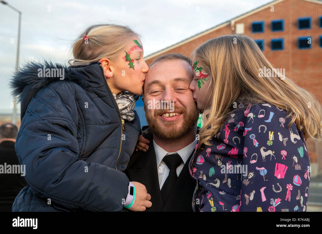 Petty Officer Michael Abley, 36, from Bordon, Hampshire, was met by his daughters Grace, (left) nine, and Evie, six after the Royal Navy aircraft carrier HMS Queen Elizabeth arrived in Portsmouth, returning home from her four-month Westlant deployment after successfully conducting flight trials of the F-35B fighter jets. Stock Photo