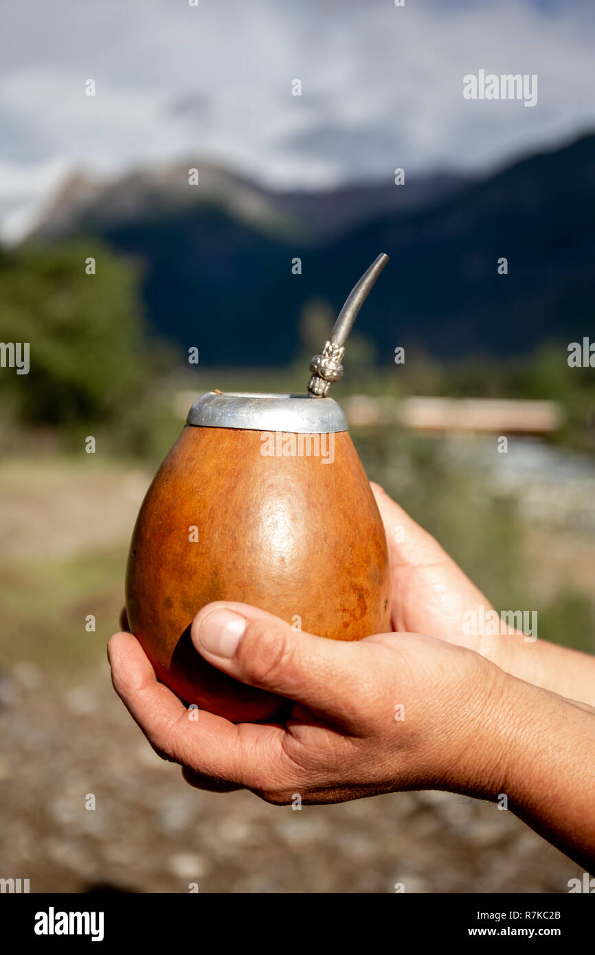 Man holding calabash yerba mate in nature. Travel and adventure concept. Latin American drink