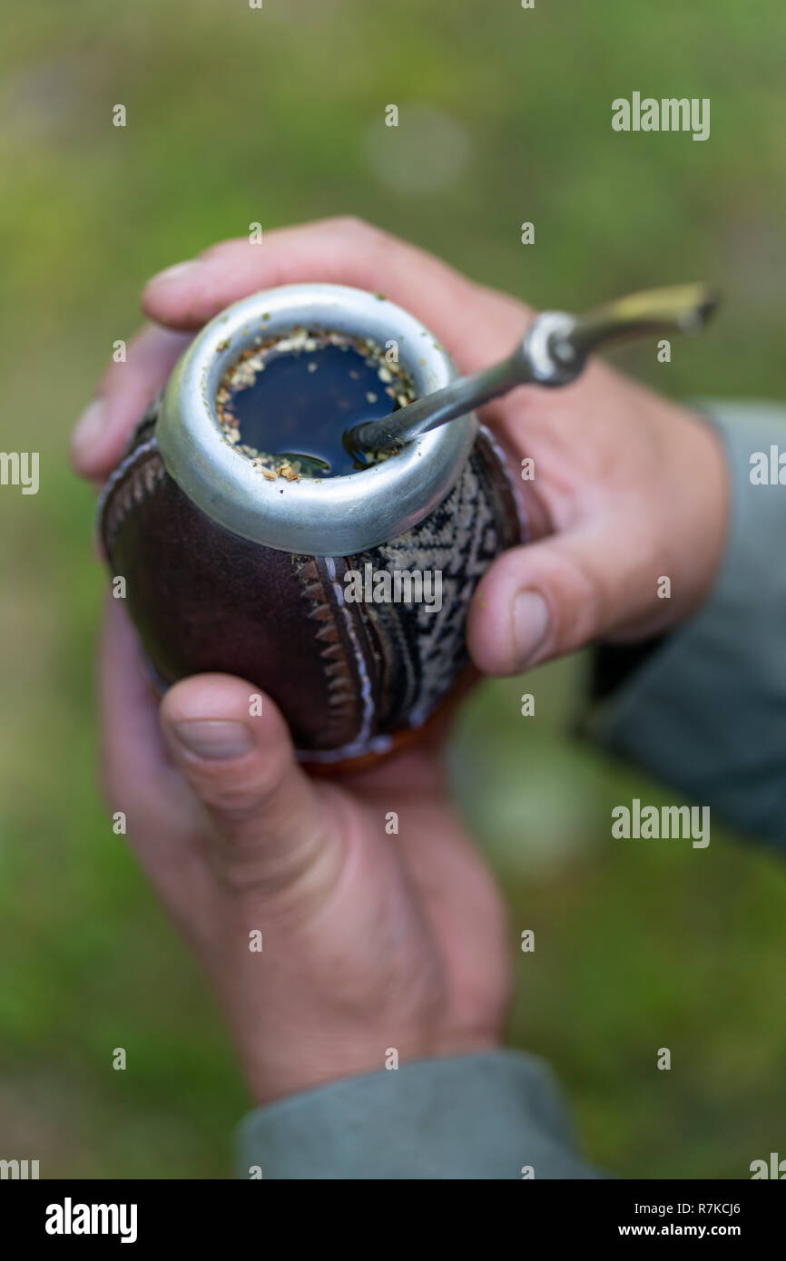 Man holding yerba mate in nature. Travel and adventure concept. Latin American drink yerba mate