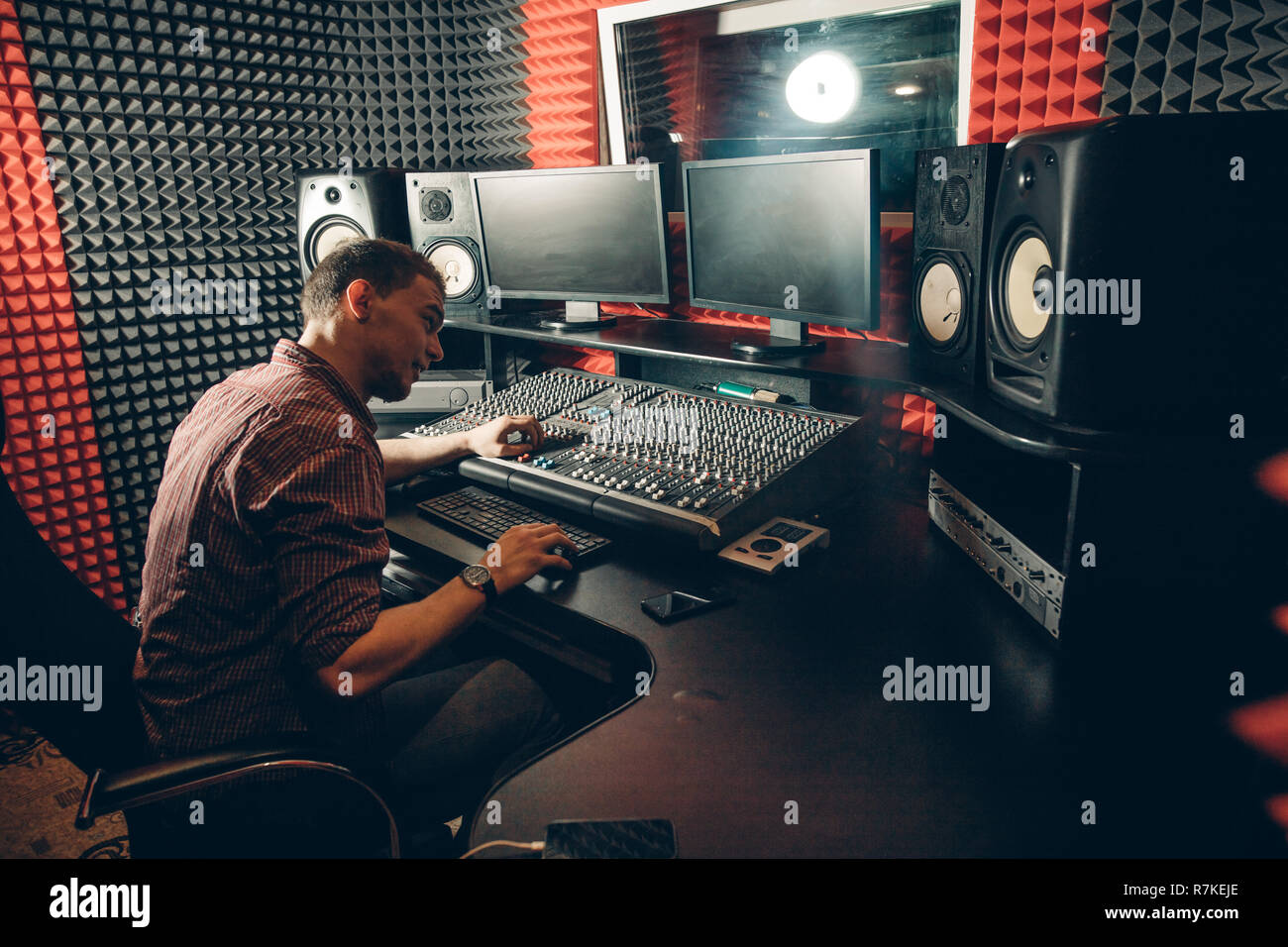 technology, and equipment concept. man controlling the sound in the studio Stock Photo