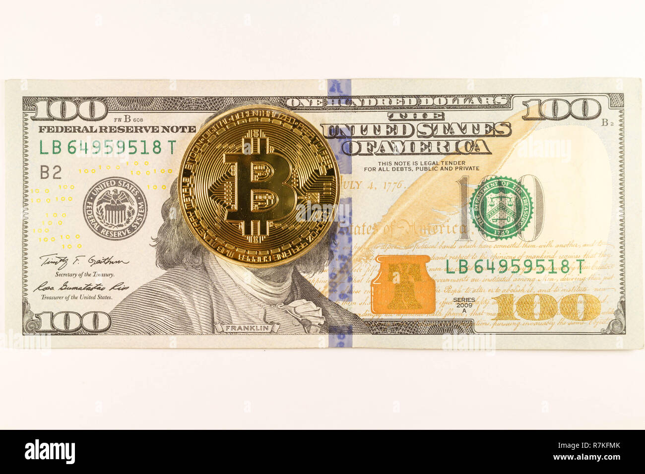 Bitcoin coin lies on a 100 dollar banknote Stock Photo - Alamy
