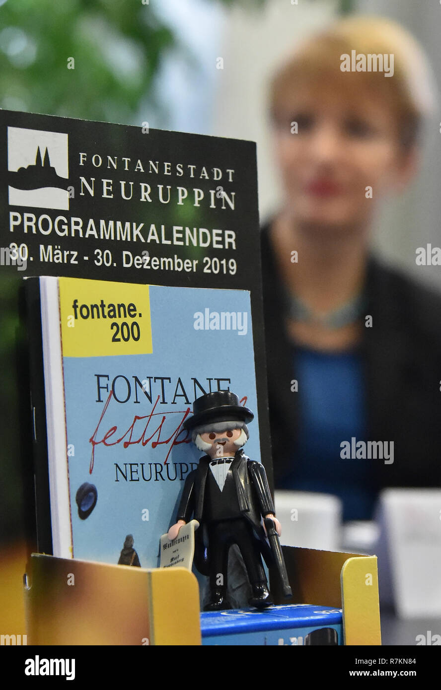Potsdam, Germany. 10th Dec, 2018. Martina Münch (SPD), Brandenburg's Minister of Culture, sits behind the display during a press conference with the programmes for the Fontane Year and a toy figure from Fontane. The writer, journalist and author Theodor Fontane (1819-1898) is honoured on the occasion of his 200th birthday in the coming year in Brandenburg. Credit: Bernd Settnik/dpa-Zentralbild/dpa/Alamy Live News Stock Photo
