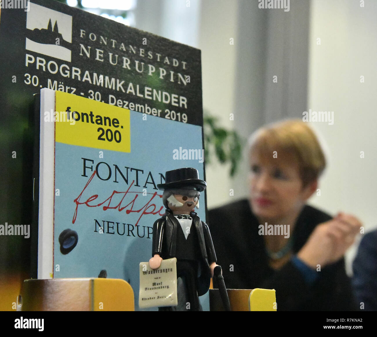 Potsdam, Germany. 10th Dec, 2018. Martina Münch (SPD), Brandenburg's Minister of Culture, sits behind the display during a press conference with the programmes for the Fontane Year and a toy figure from Fontane. The writer, journalist and author Theodor Fontane (1819-1898) is honoured on the occasion of his 200th birthday in the coming year in Brandenburg. Credit: Bernd Settnik/dpa-Zentralbild/dpa/Alamy Live News Stock Photo