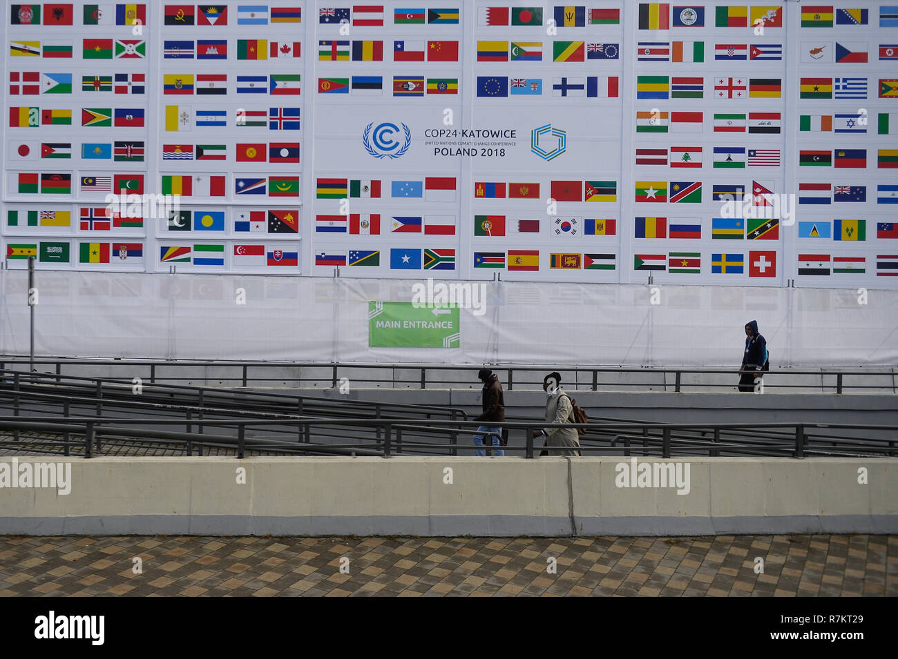 People seen passing by COP24 members flags during the UN Climate change conference (COP24). The 2018 United Nations climate change conference (COP24) is now entering the second week of negotiations and ends on 14th December in Katowice. Stock Photo